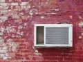 Old AC unit on the old red brick wall.