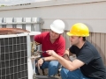 Instructor trains student to repair air conditioning compressor.